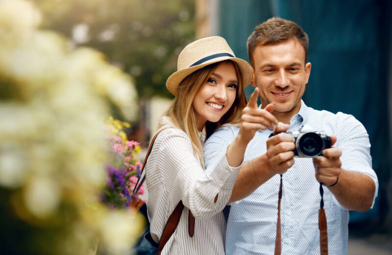 Zwei Touristen die ein Foto von einer Attraktion nehmen