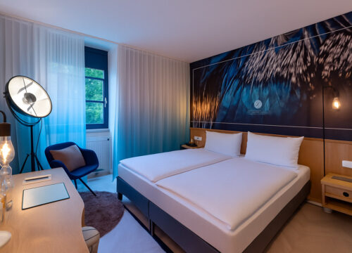 Ein Doppelzimmer mit Doppelbett, Sessel und Schreibtisch im Arthotel ANA Aura