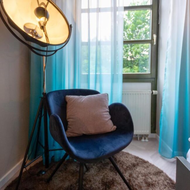 Ein Sessel und eine Lampe im im Arthotel ANA Aura