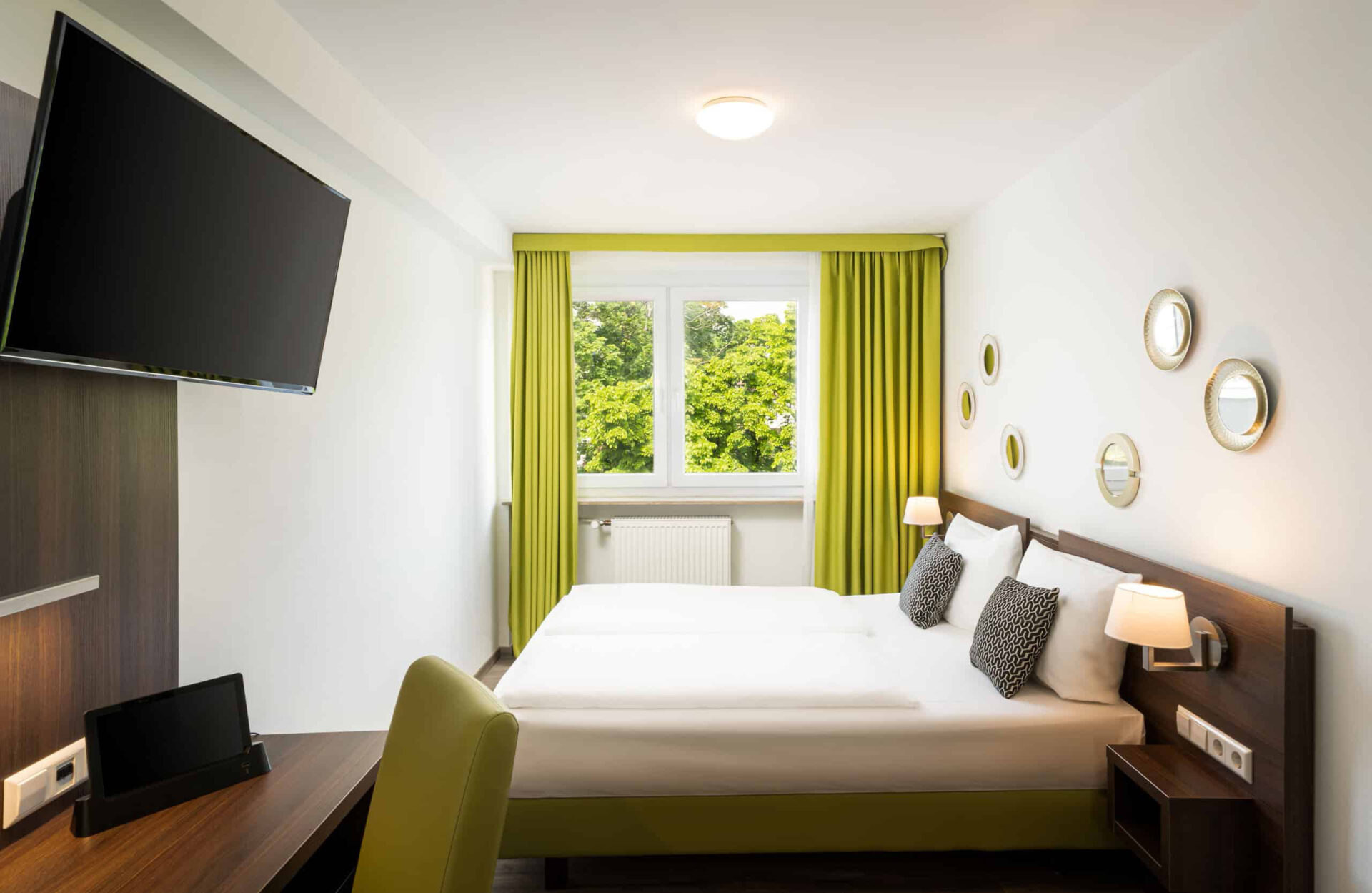 Ein Doppelzimmer mit Bett. Fernseher und Wanddekoration im Arthotel ANA Eden
