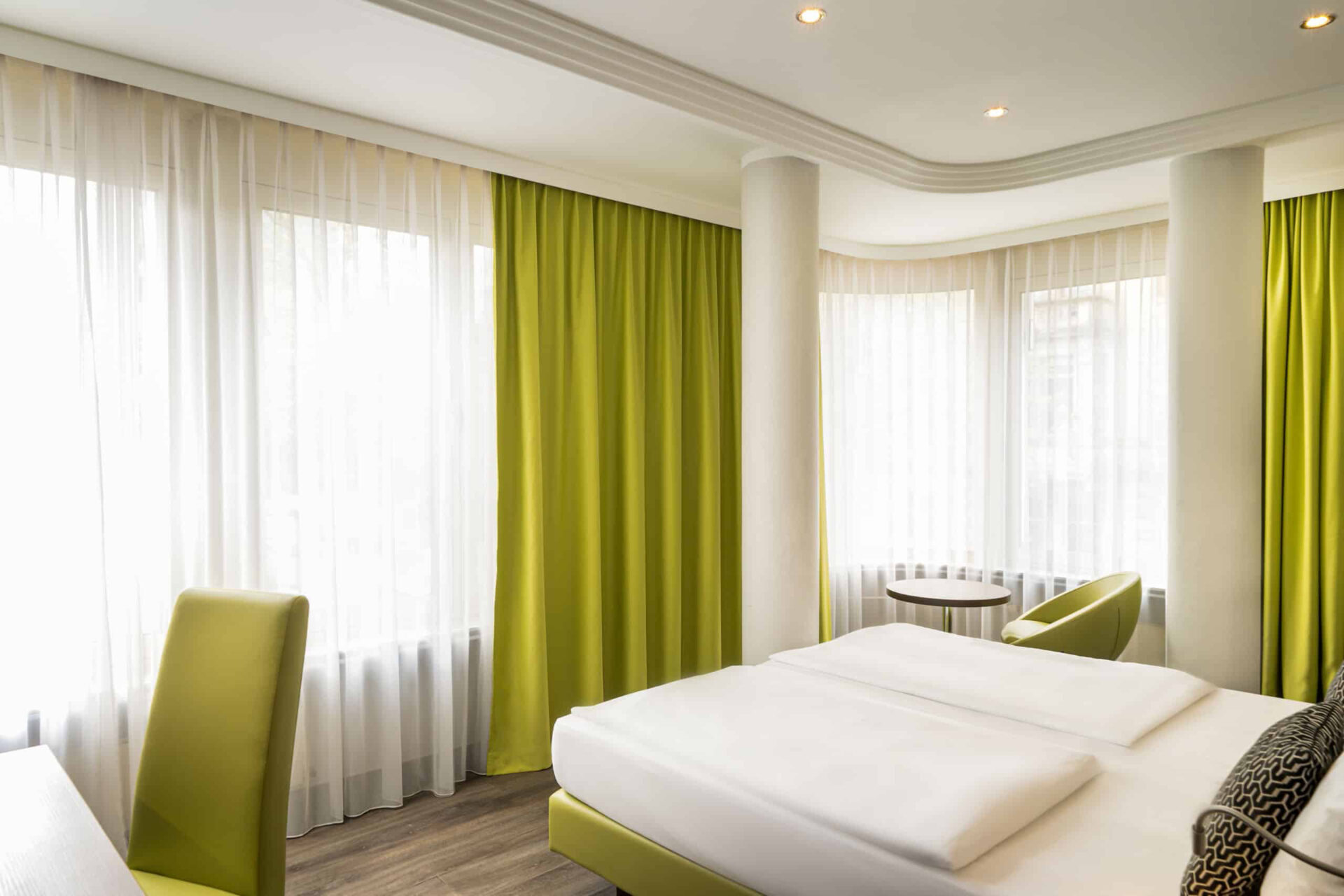 Queransicht eines Doppelzimmers mit Doppelbett, Sessel und Schreibtisch im Arthotel ANA Eden