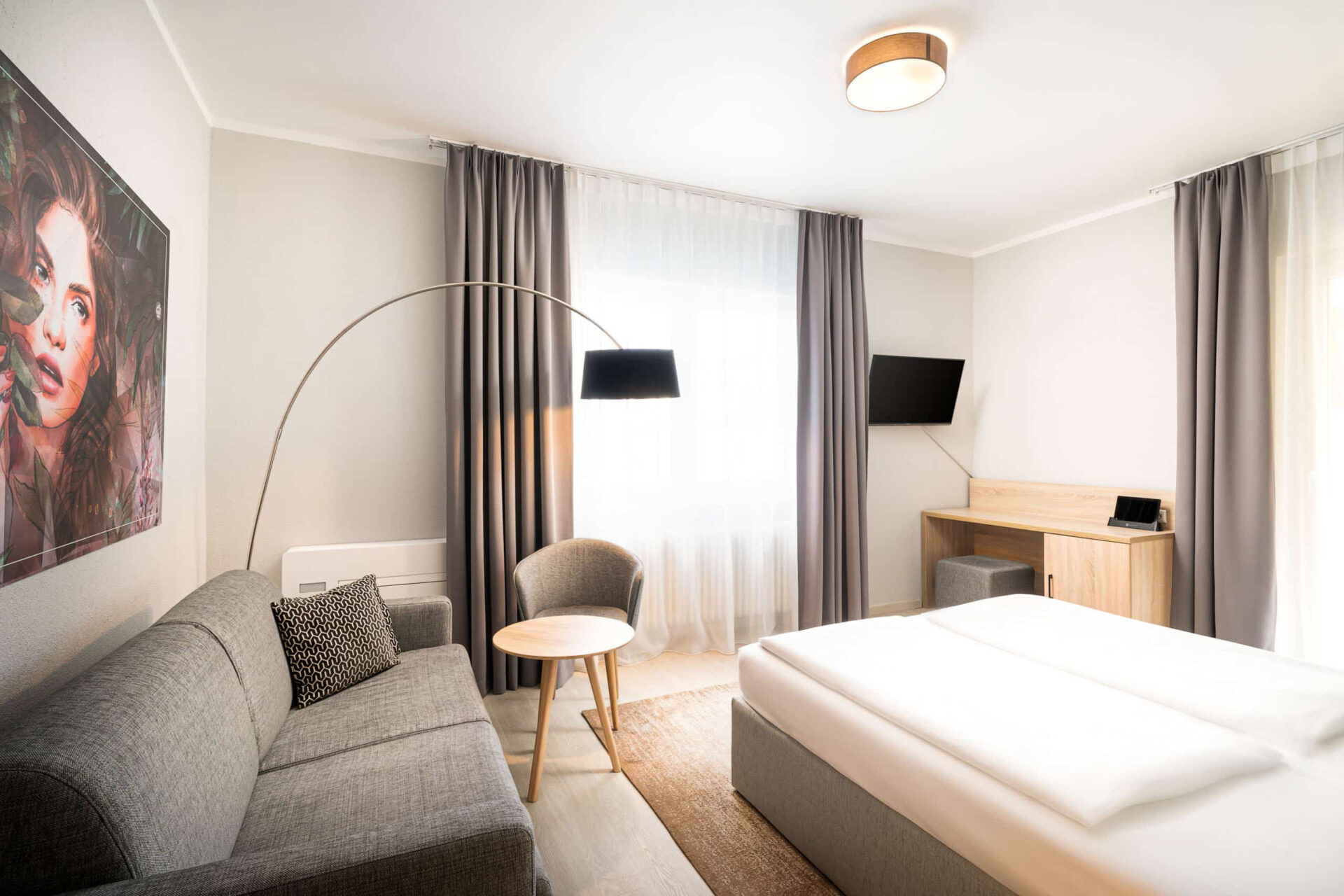 Ein Zimmer mit Sofa, Lampen, Schreibtisch und Bett im Arthotel ANA Eden 