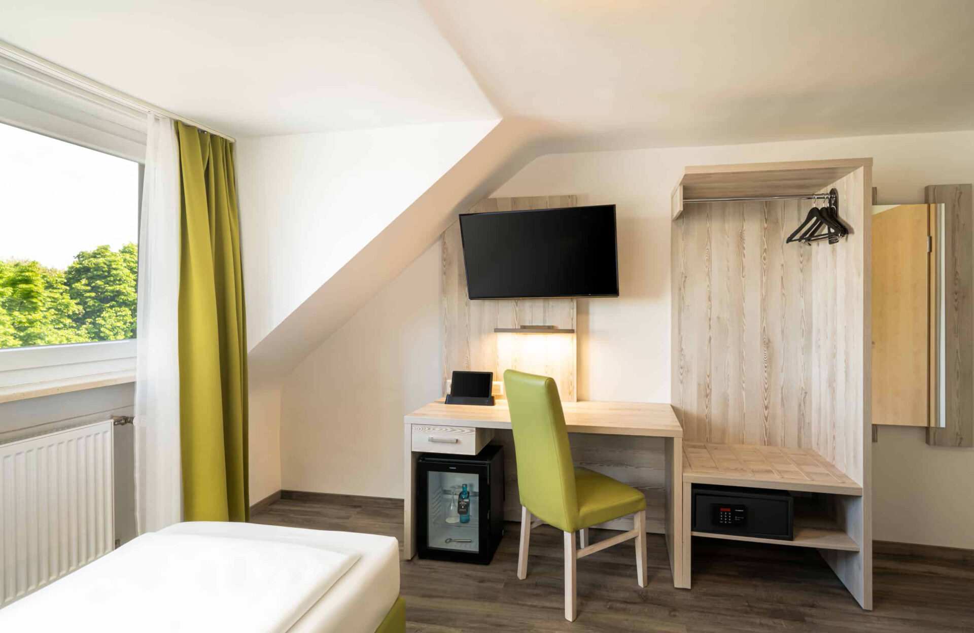 Der Schreibtisch und der Ankleidebereich eines Zimmers im Arthotel ANA Eden