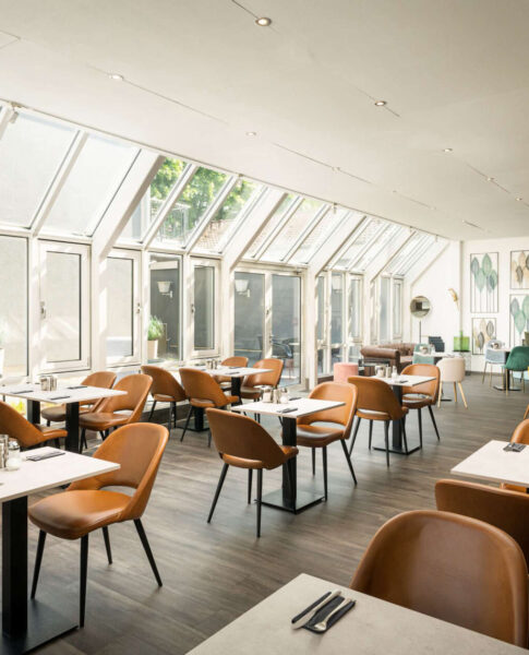 Der Frühstücksbereich mit Tischen und Stühlen im Arthotel ANA Eden