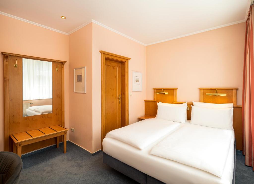 Ein Doppelzimmer mit Bett, Nachttischlampen und Kofferablage im Arthotel ANA Fleur 