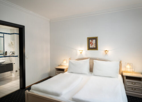 Ein Doppelzimmer mit Doppelbett, Badezimmer und Wandbild im Arthotel ANA Gala