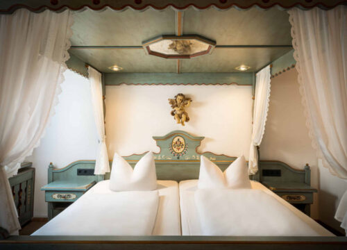 Die Junior Suite mit Doppelbett und Nachttischen im Arthotel ANA Goggl