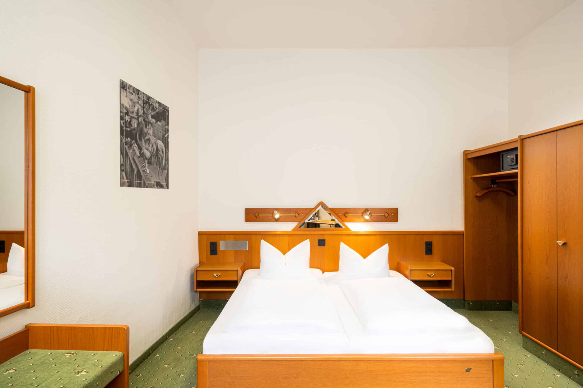 Ein Doppelzimmer mit Bett, Kleiderschrank und Safe im Arthotel ANA Goggl