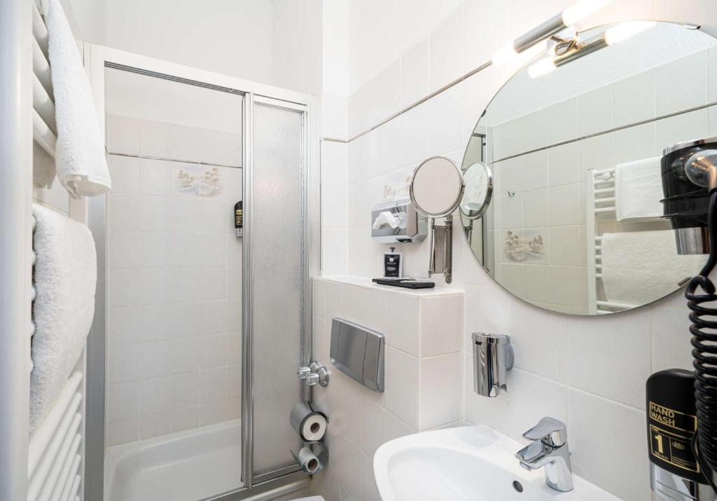 Ein Badezimmer mit Dusche, Handtuchhalterung und Waschbecken im Arthotel ANA Gold