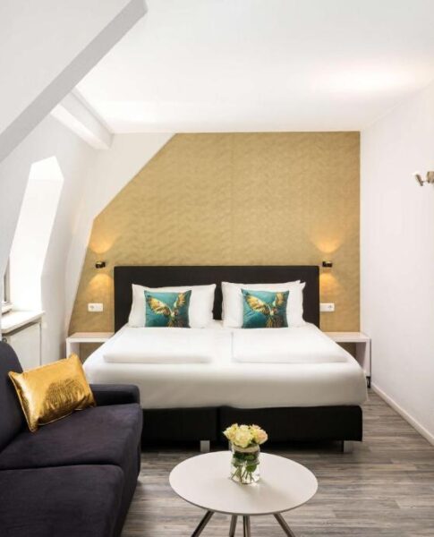 Ein Doppelzimmer mit Sofa und Beistelltisch im Arthotel ANA Gold