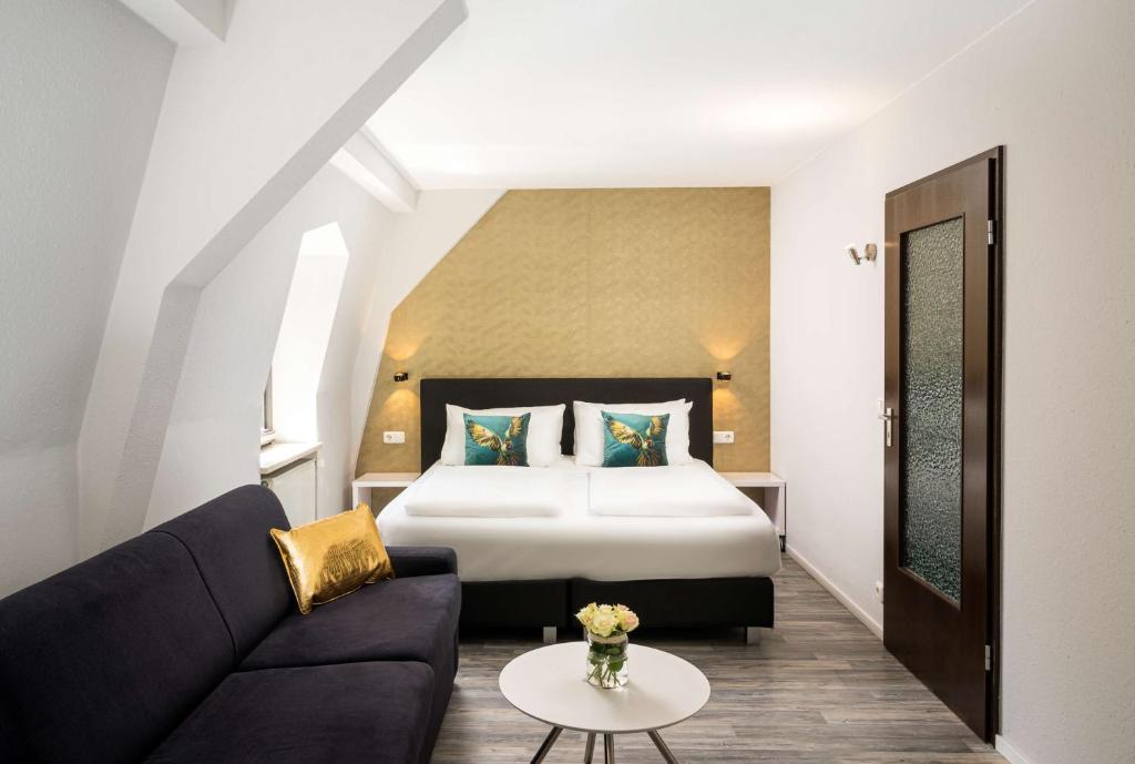 Ein Doppelzimmer mit Sofa und Beistelltisch im Arthotel ANA Gold