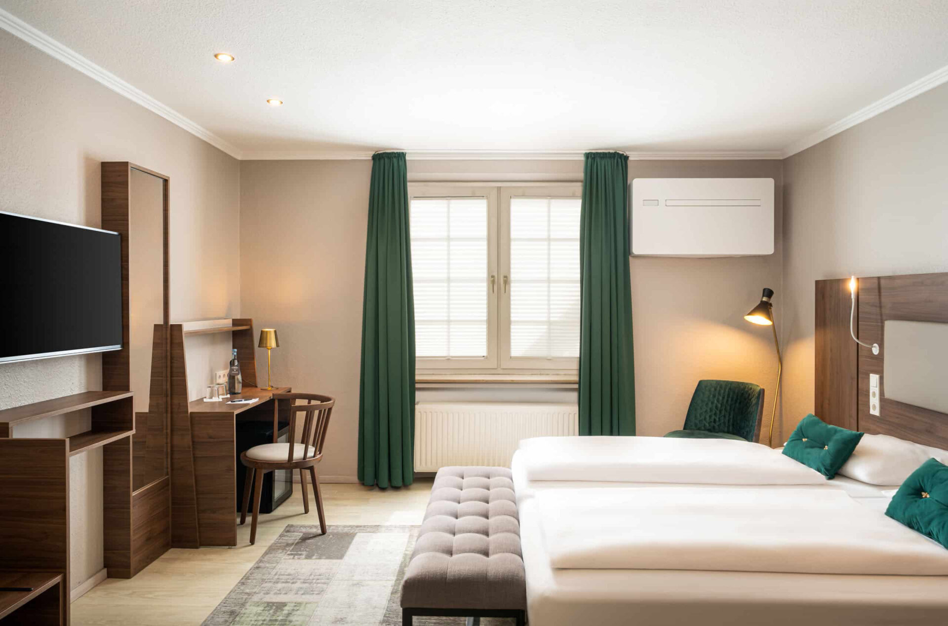 Ein Doppelzimmer mit Doppelbett, großem Fenster und Schreibtisch im Arthotel ANA Liberty Bremen