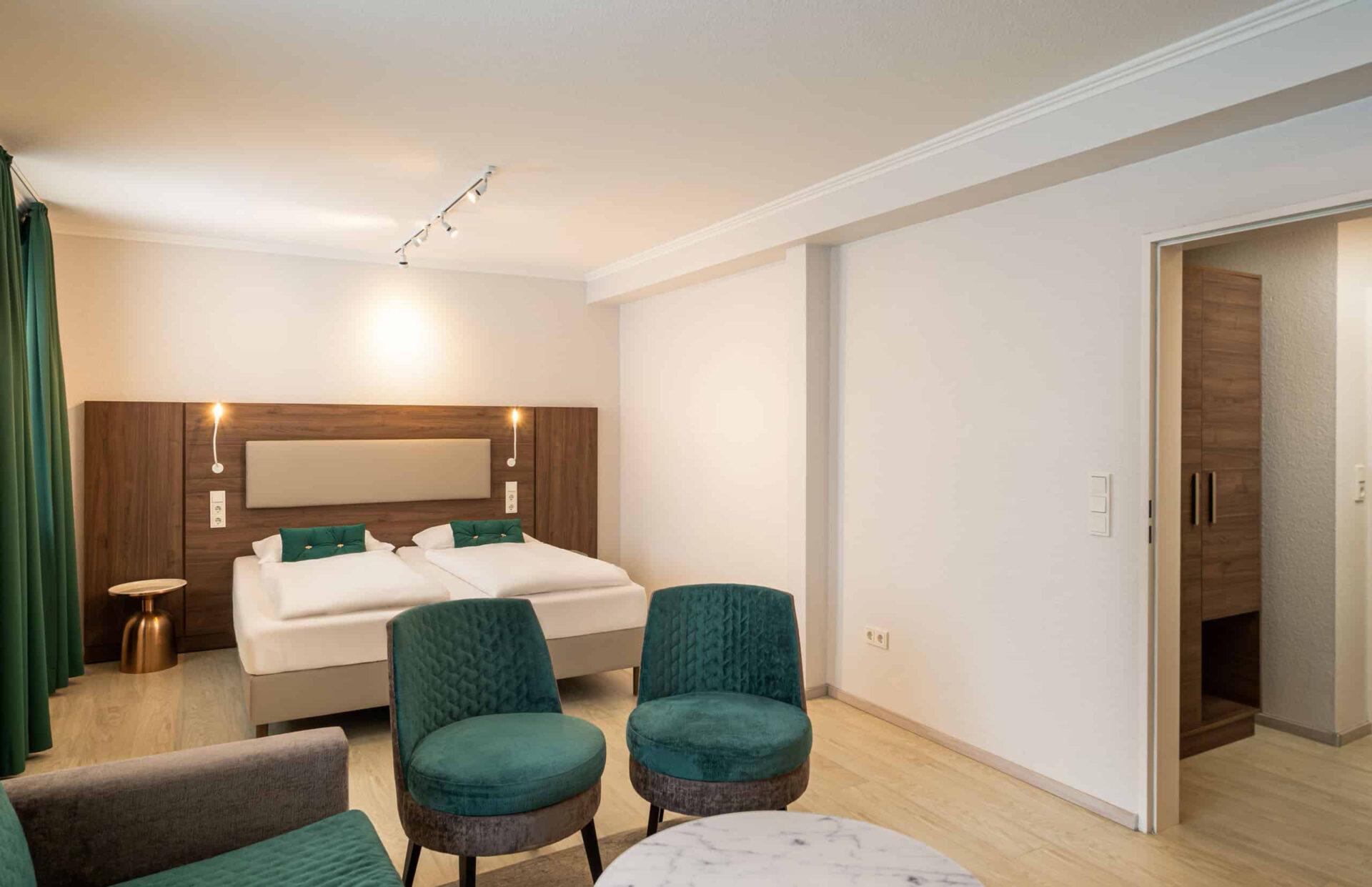 Der Kleiderschrank, das Doppelbett und die Nachttische eines Dreibettzimmers im Arthotel ANA Liberty Bremen