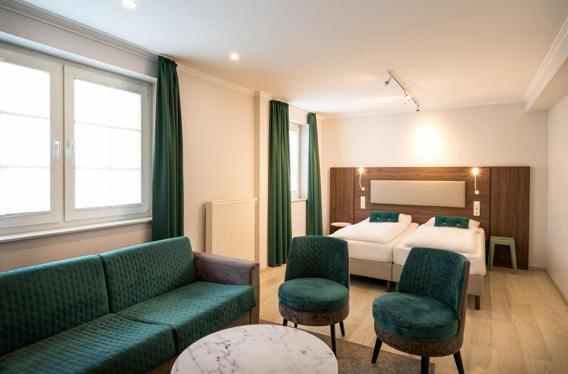 Das Doppelbett und die Sitzecke eines Dreibettzimmers im Arthotel ANA Liberty Bremen