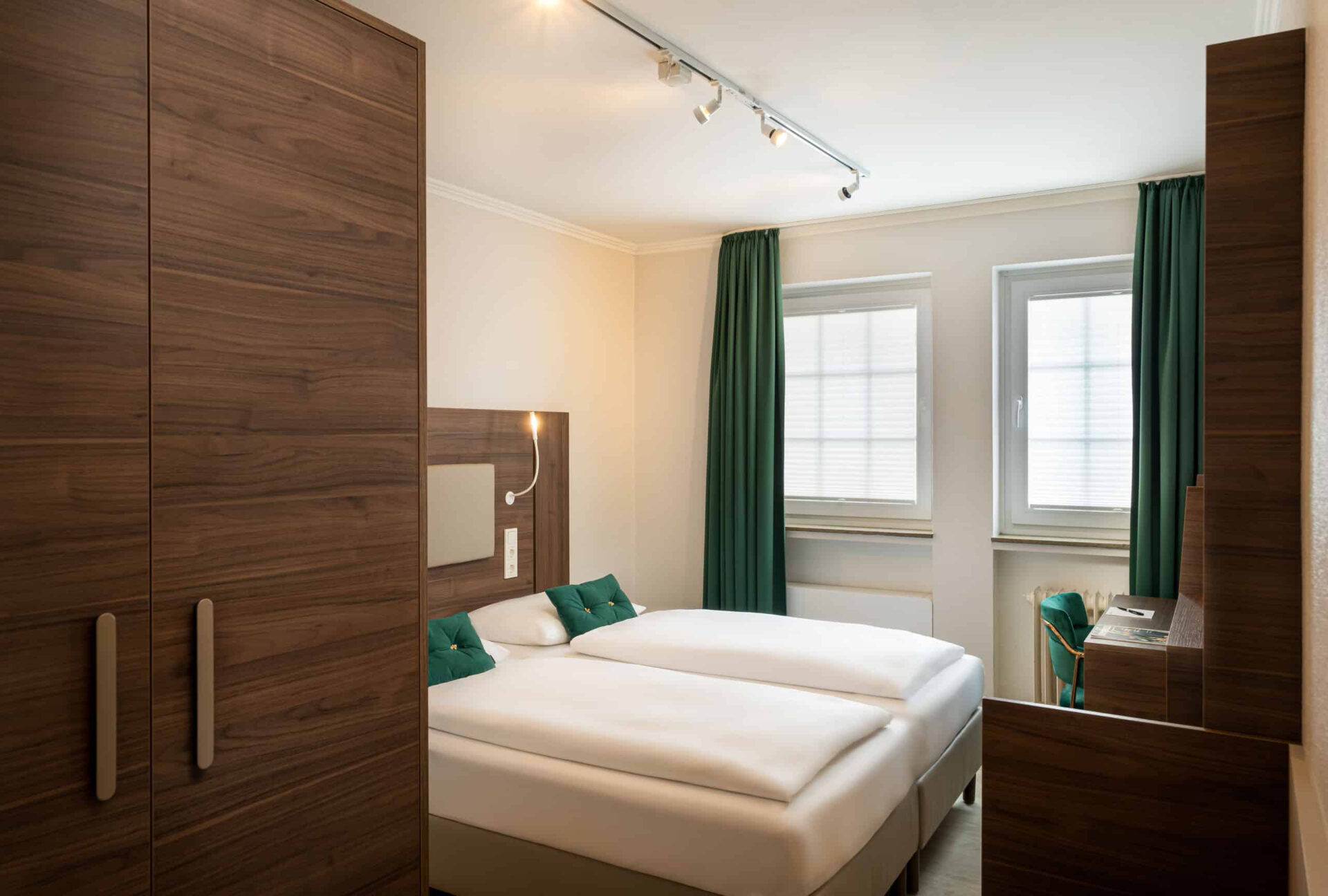 Ein Doppelzimmer mit Doppelbett, Vorhängen und Kleiderschrank im Arthotel ANA Liberty Bremen