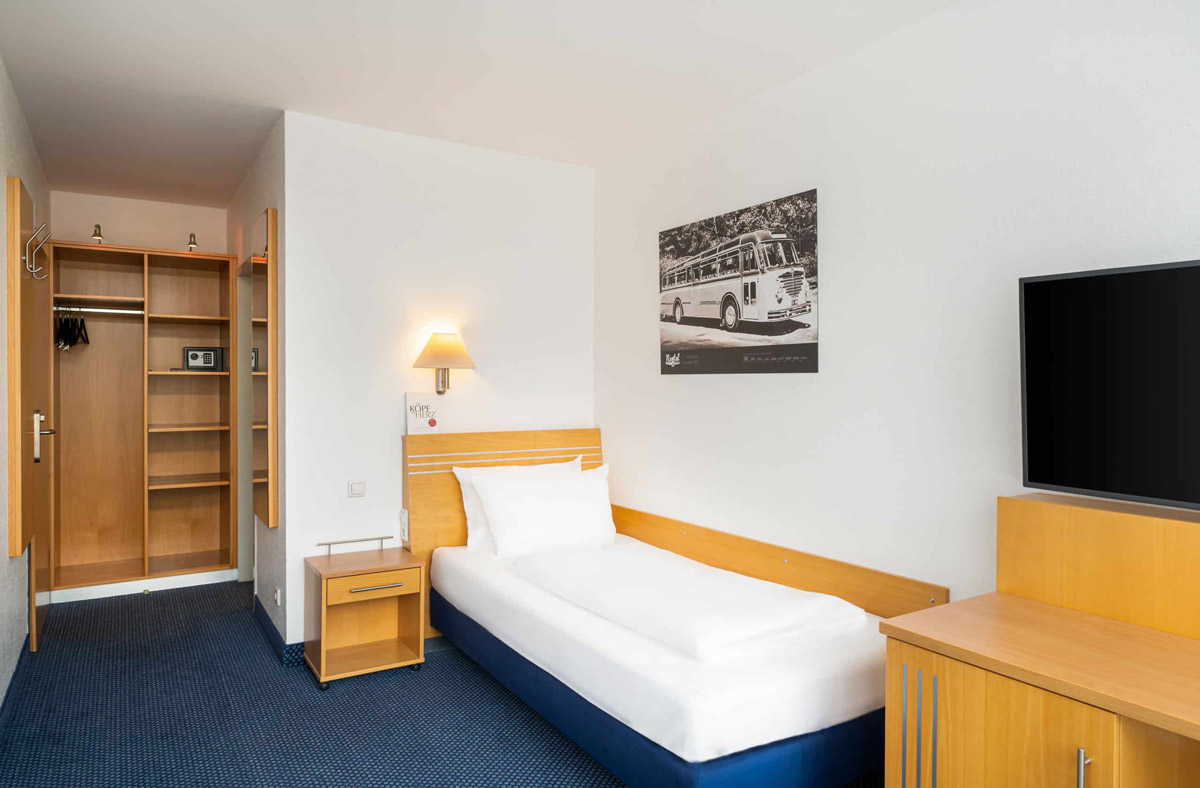 Ein Einzelzimmer mit Einzelbett, Kleiderschrank und Safe im Arthotel ANA Neotel Stuttgart
