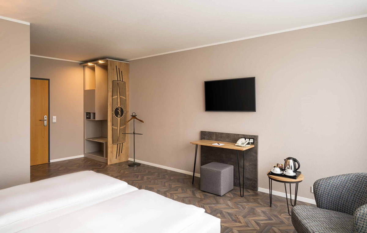 Der Schreibtisch und der Kleiderschrank mit Safe eines Zimmers im Arthotel ANA Neotel Stuttgart