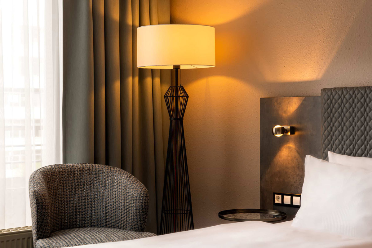 Der Nachttisch und die Lampe sowie der Sessel eines Zimmers im Arthotel ANA Neotel Stuttgart