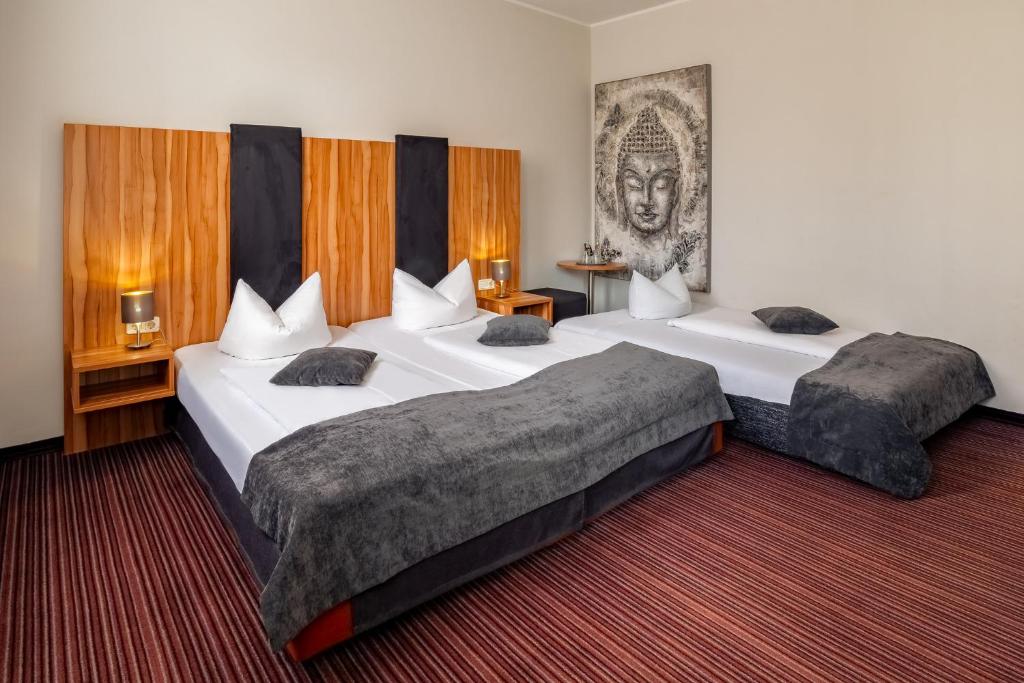 Ein Dreibettzimmer mit einem Doppelbett und einem Einzelbett im Arthotel ANA Style