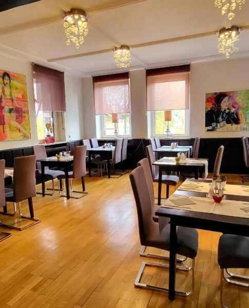 Der Essensbereich mit Tischen und Stühlen im Arthotel ANA Style