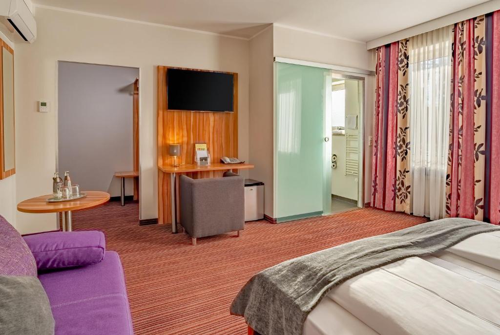 Ein Doppelzimmer mit Sofa und Schreibtisch im Arthotel ANA Style