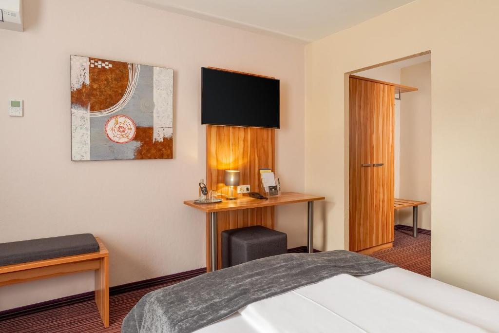 Ein Einzelzimmer mit Fernseher und Schreibtisch im Arthotel ANA Style