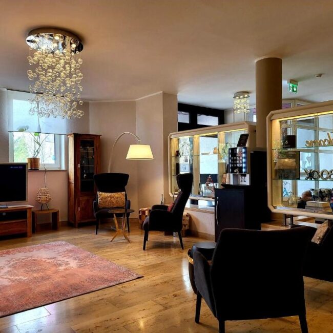 Der Eingangsbereich mit Sesseln und Fernseher im Arthotel ANA Style