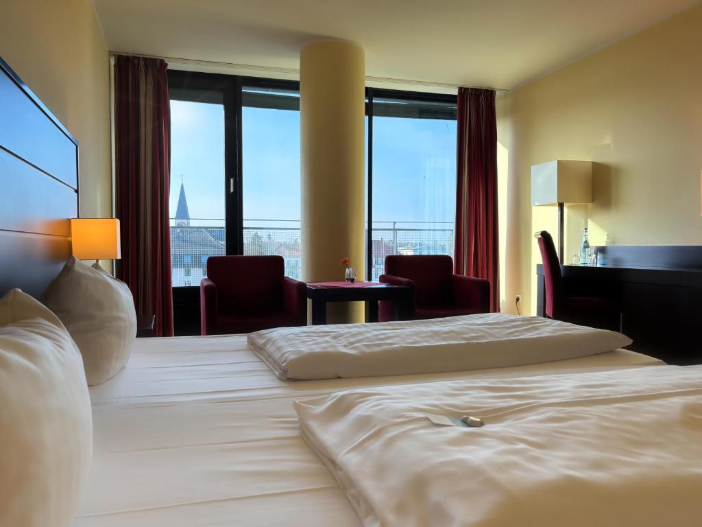 Ein Doppelzimmer mit Sesseln im Aspire Acara Oldenburg