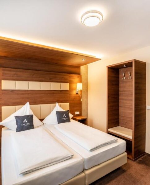 Ein Doppelzimmer mit Sicht auf den Kleiderschrank und das Bett im Aspire Castillo Reutlingen