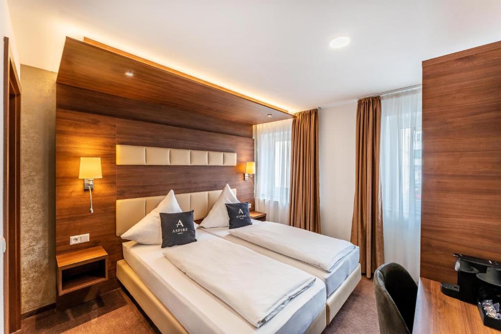 Ein Doppelzimmer mit zwei Fenstern, einer Kaffeemaschine und einem Bett im Aspire Castillo Reutlingen