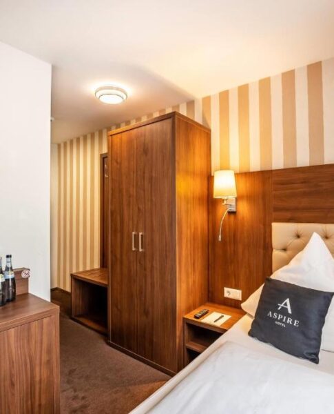 Ein Einzelzimmer mit Kleiderschrank und Schreibtisch im Aspire Castillo Reutlingen