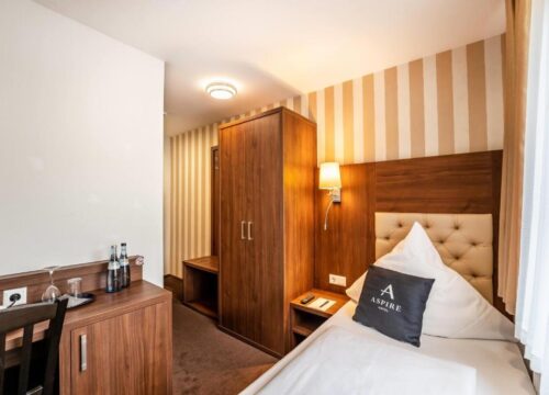 Ein Einzelzimmer mit Kleiderschrank und Schreibtisch im Aspire Castillo Reutlingen 