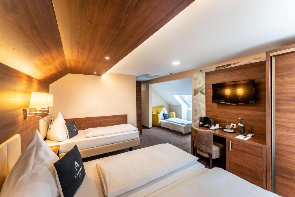 Ein Vierbettzimmer mit einem Doppelbett und zwei Einzelbetten im Aspire Castillo Reutlingen