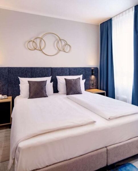 Ein Doppelzimmer mit Sicht auf das Fenster mit Vorhängen im Aspire Elements Reutlingen