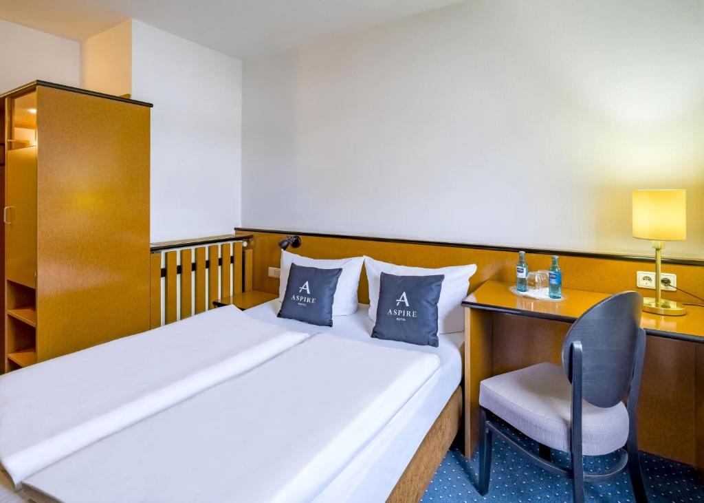 Ein Doppelzimmer mit Doppelbett und Schreibtisch im Aspire Frankfurt Airport
