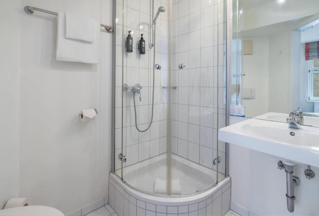Die Dusche und das Waschbecken eines Badezimmers im Aspire Kronprinz