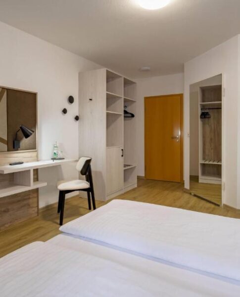 Ein Doppelzimmer mit Fernseher und Spiegel im Aspire Kronprinz 