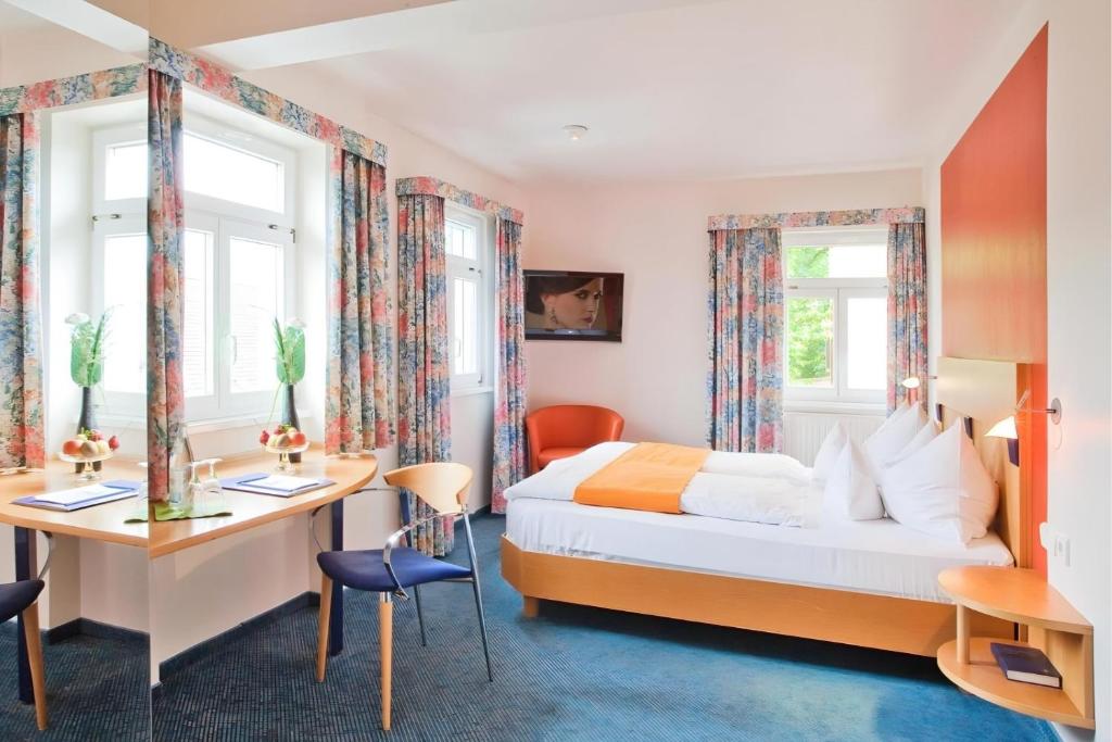 Ein Doppelzimmer mit Schreibtisch im Aspire Kronprinz 