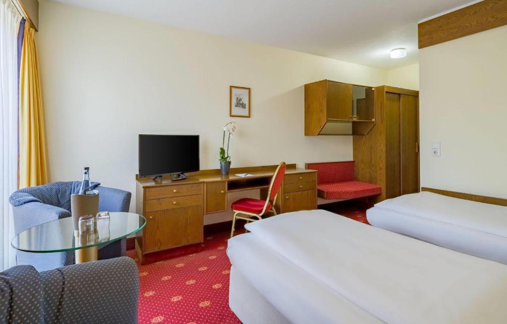 Ein Twin-Zimmer mit Sesseln und Schreibtisch im Aspire Oldenburg