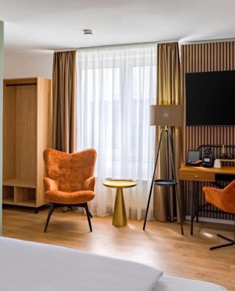 Der Schreibtisch und der Fernseher eines Zimmers im Aspire Palais Recklinghausen