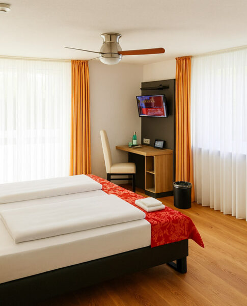 Das Bett und der Schreibtisch eines Doppelzimmers im Bodensee Hotel Kreuz