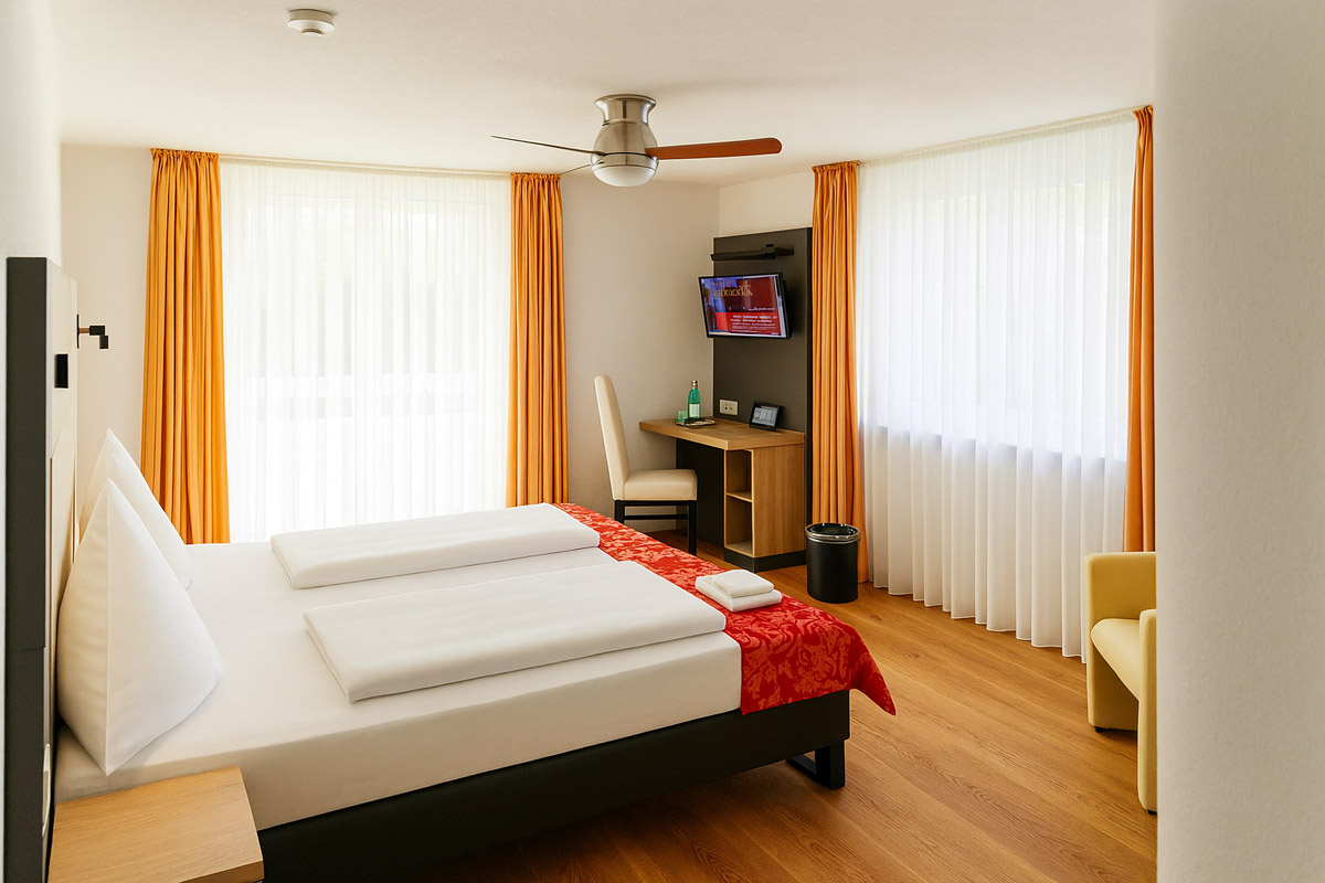 Das Bett und der Schreibtisch eines Doppelzimmers im Bodensee Hotel Kreuz