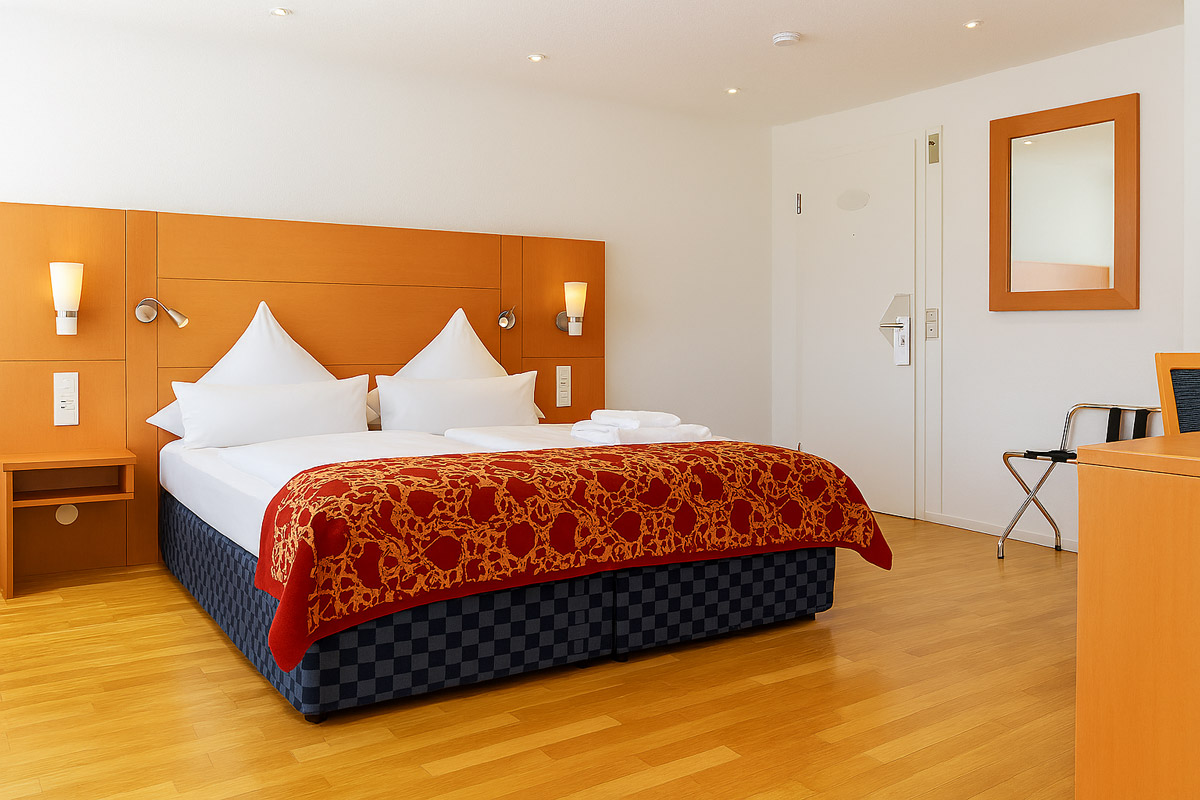 Ein Doppelzimmer mit Bett und Nachttischen im Bodensee Hotel Kreuz
