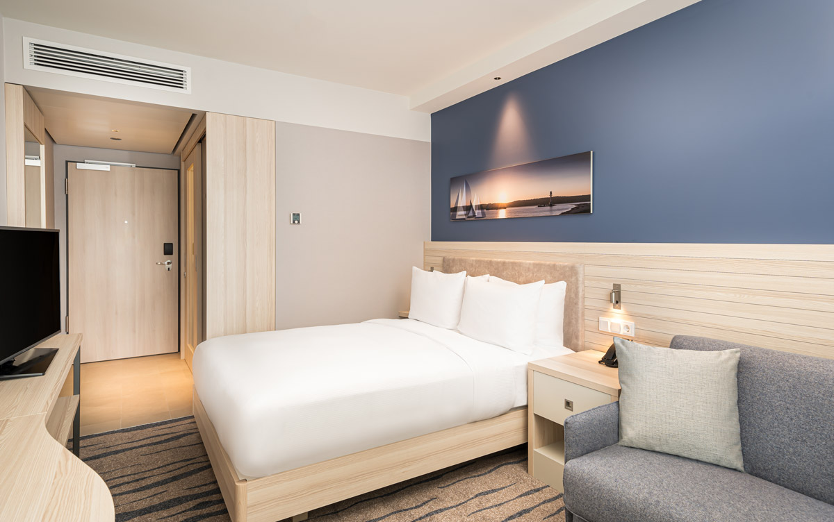 Ein Doppelbett und Nachtischlampen im Hampton by Hilton Kiel