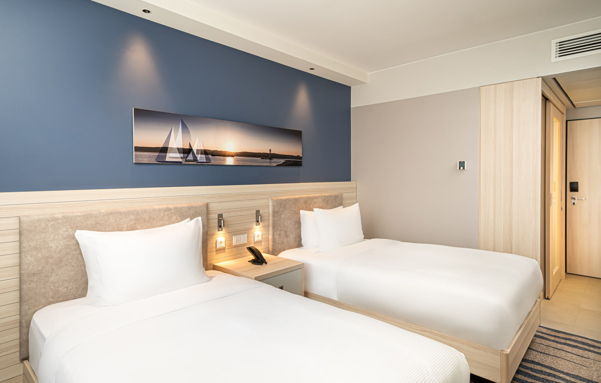 Ein Twin-Zimmer mit Einzelbetten und Lampen im Hampton by Hilton Kiel
