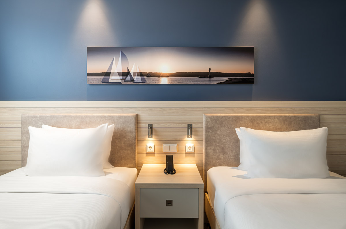 Ein Zimmer mit Einzelbetten und Wanddekoration im Hampton by Hilton Kiel