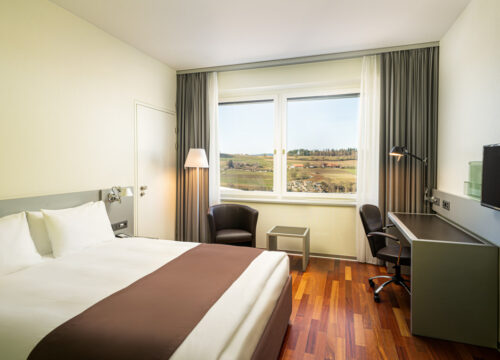 Die Ausstattung eines Zimmers mit Blick in die Natur im Holiday Inn Bern-Westside