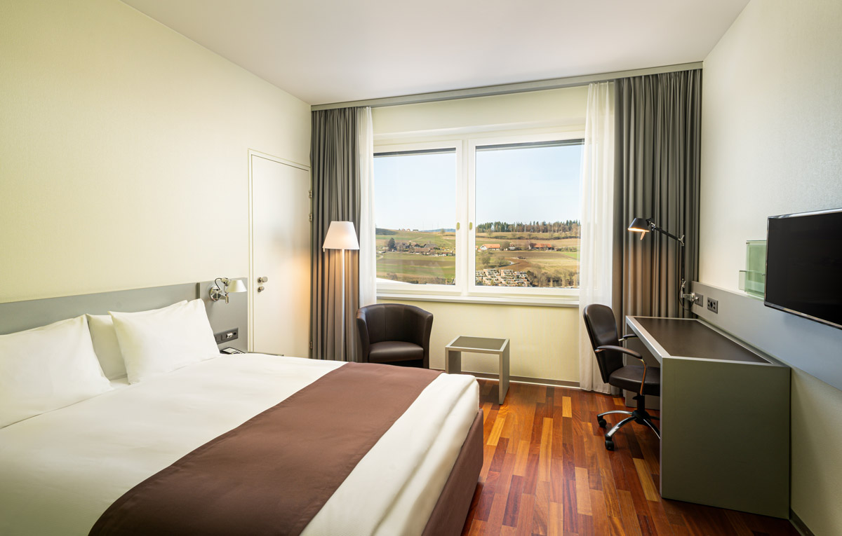 Die Ausstattung eines Zimmers mit Blick in die Natur im Holiday Inn Bern-Westside