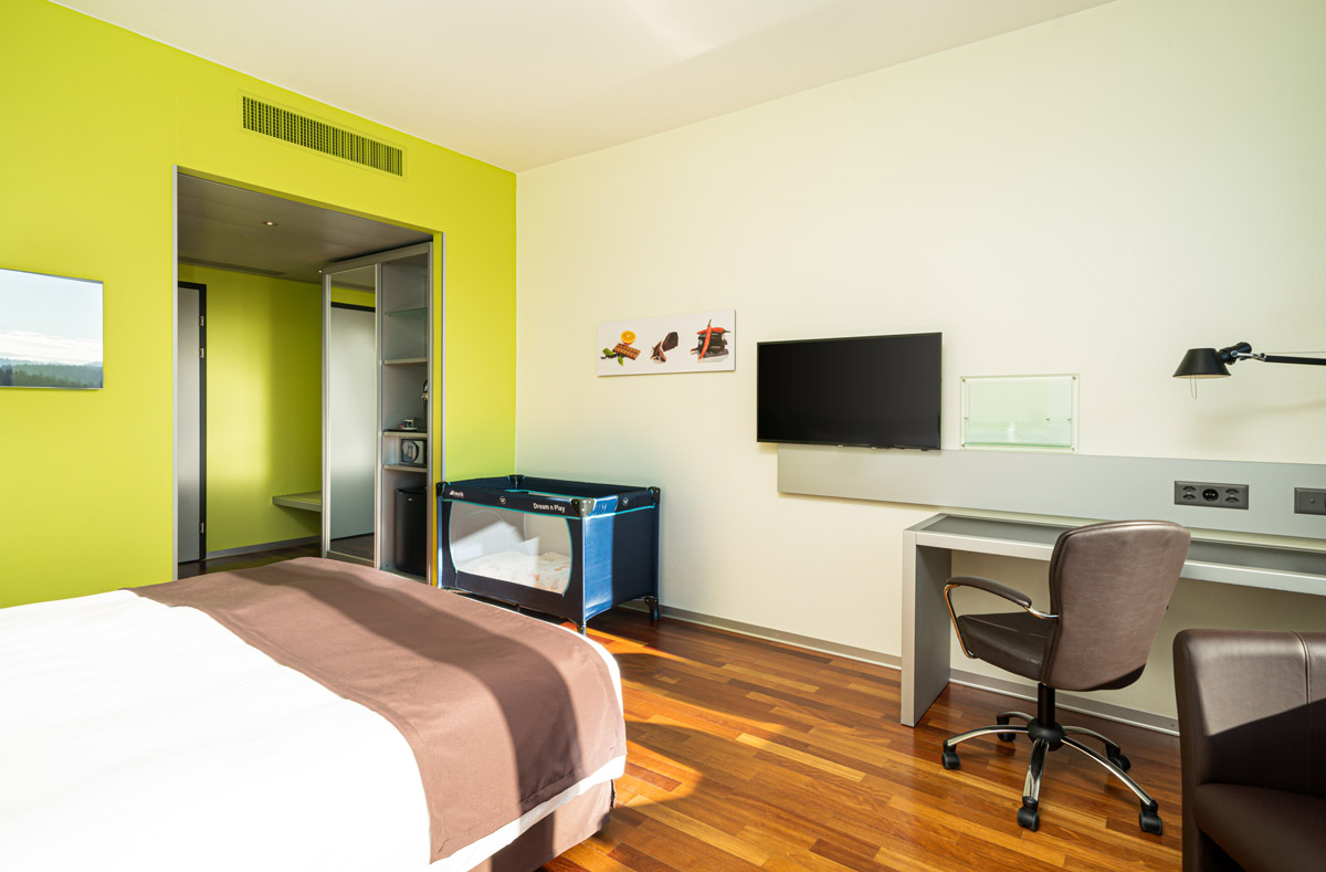 Ein Zimmer mit Babybett im Holiday Inn Bern-Westside