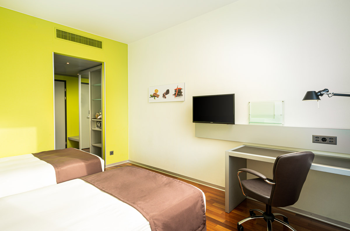 Ein Twin-Zimmer mit Einzelbetten und Schreibtisch im Holiday Inn Bern-Westside